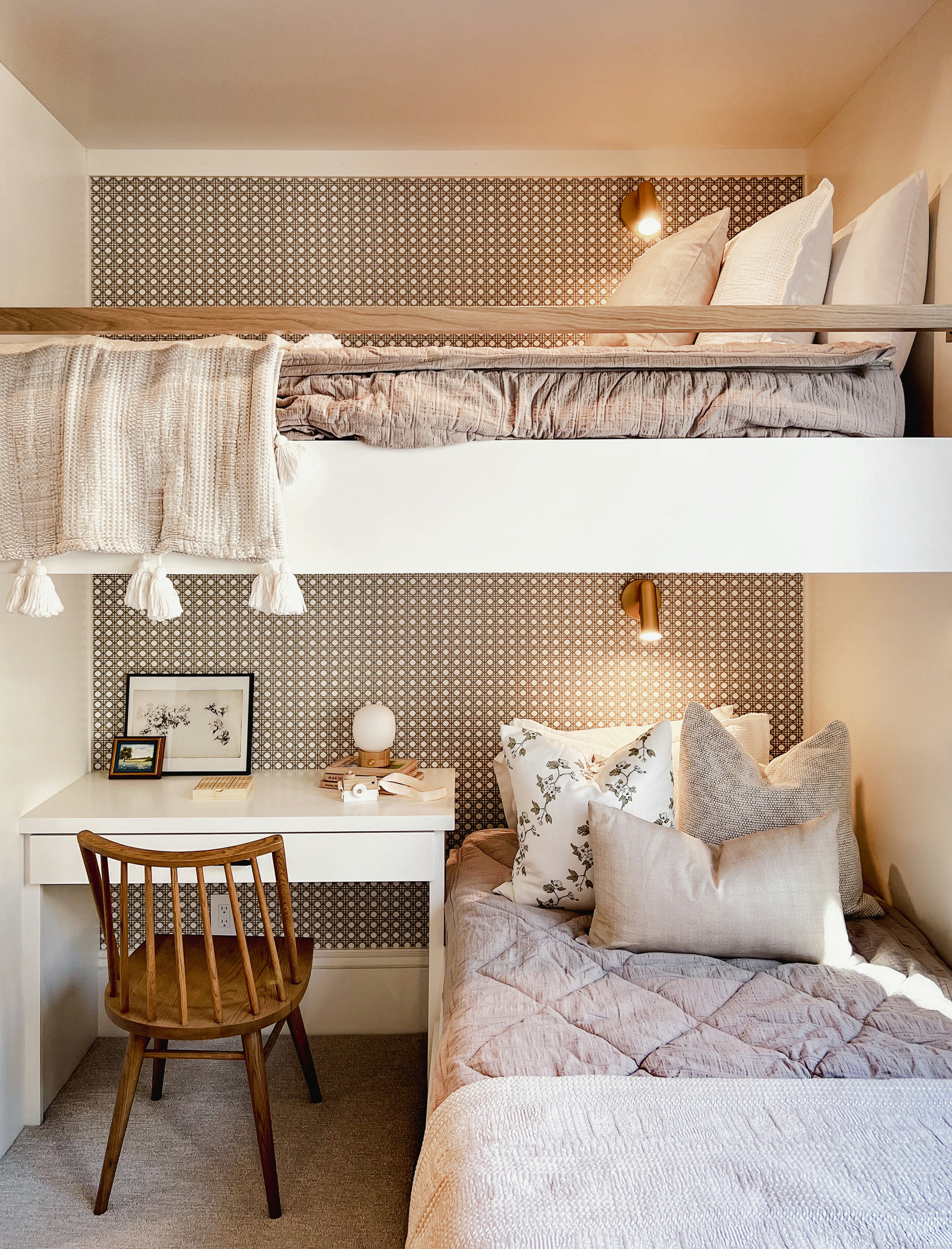 a bedroom with two bunk beds and a desk